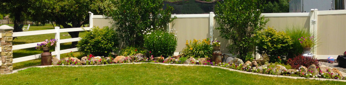 Two-Tone Vinyl Privacy Fence with Gate (on Right) Next to Flower Bed