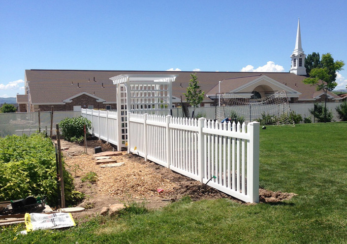 Vinyl picket fence in front of garden--side view.