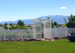 Vinyl picket fence in front of garden.