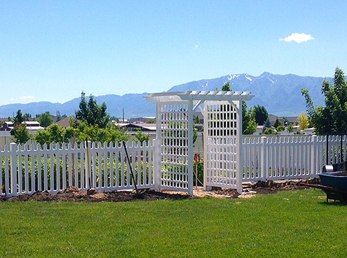 Vinyl picket fence in front of garden.